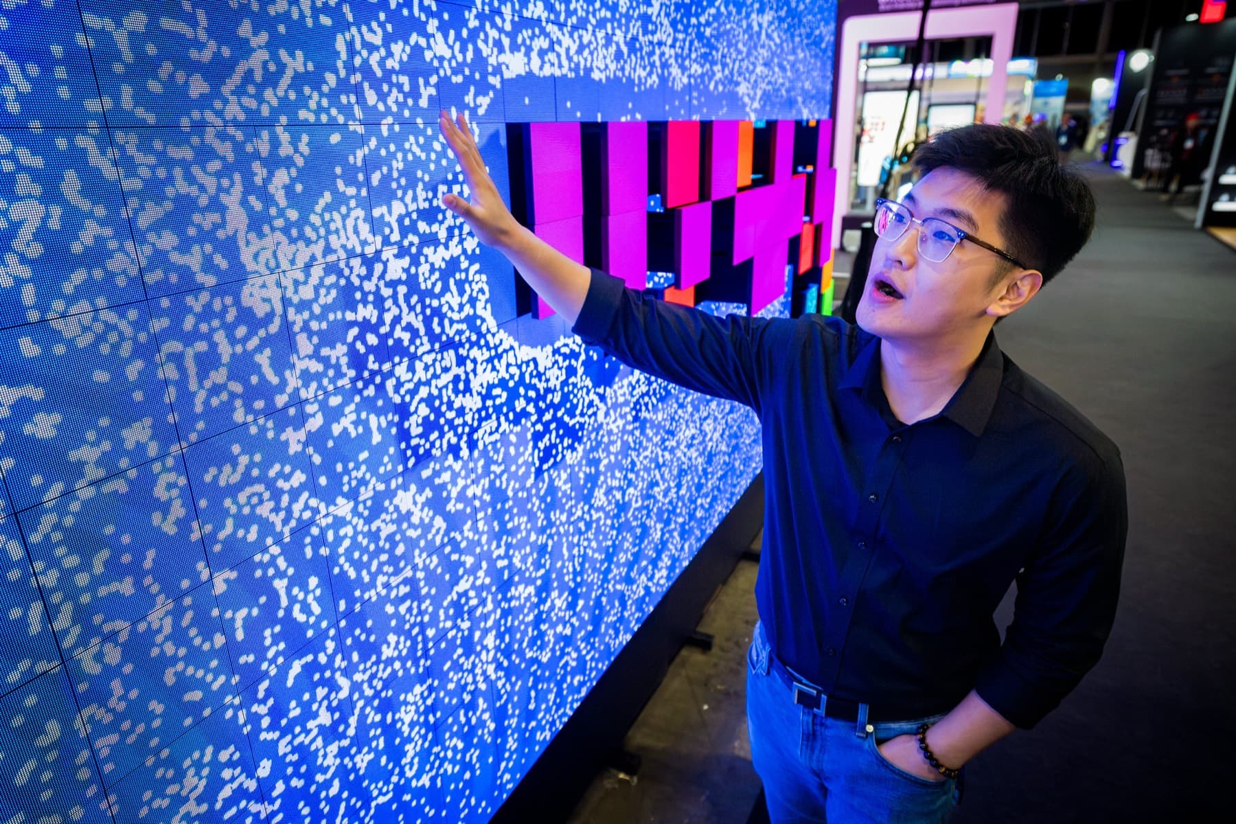 Bezoeker raakt een blauwe interactieve LED-wall aan