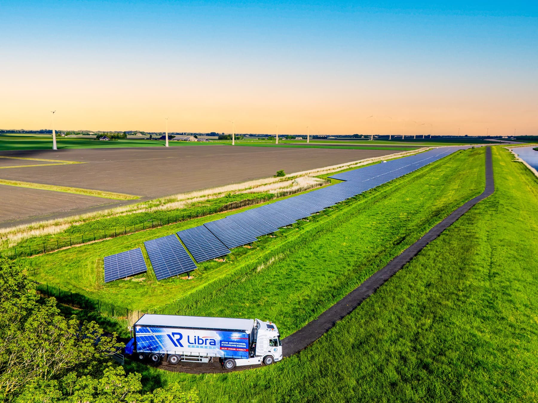 Luchtfoto van een zonnepark langs de dijk