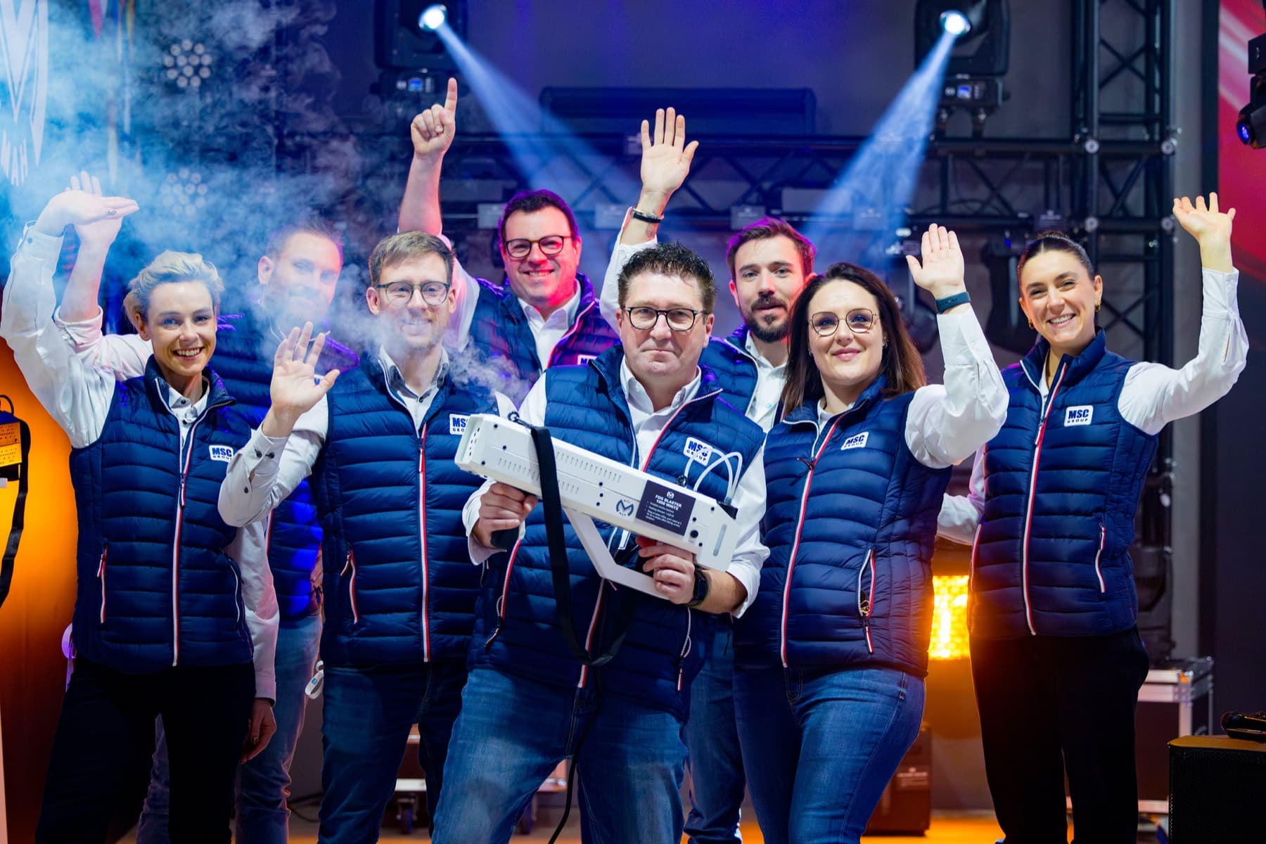 Team viert een succes met de handen in de lucht op een podium