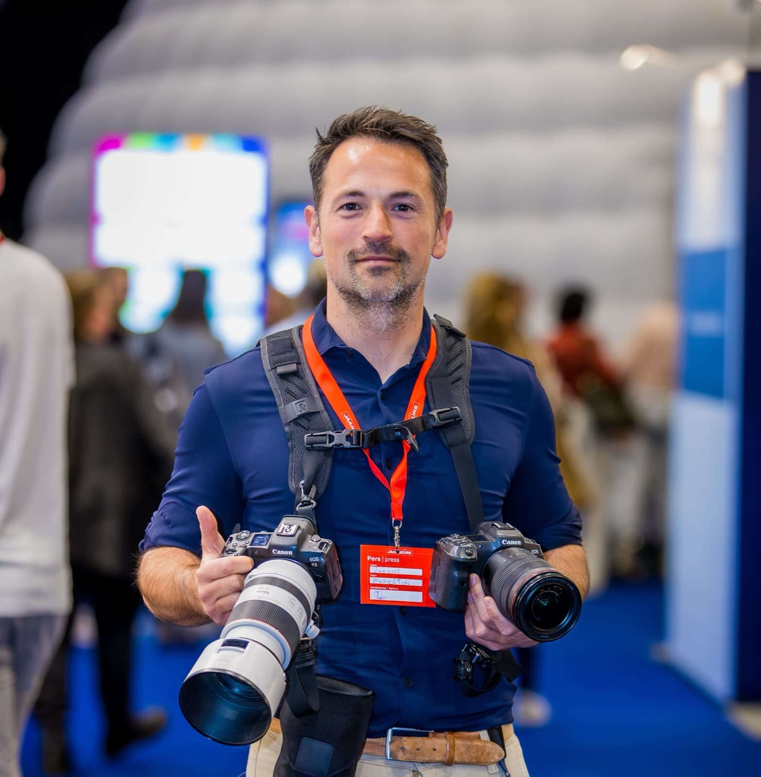 Michiel Ton, eventfotograaf, met twee camera’s op een beurs