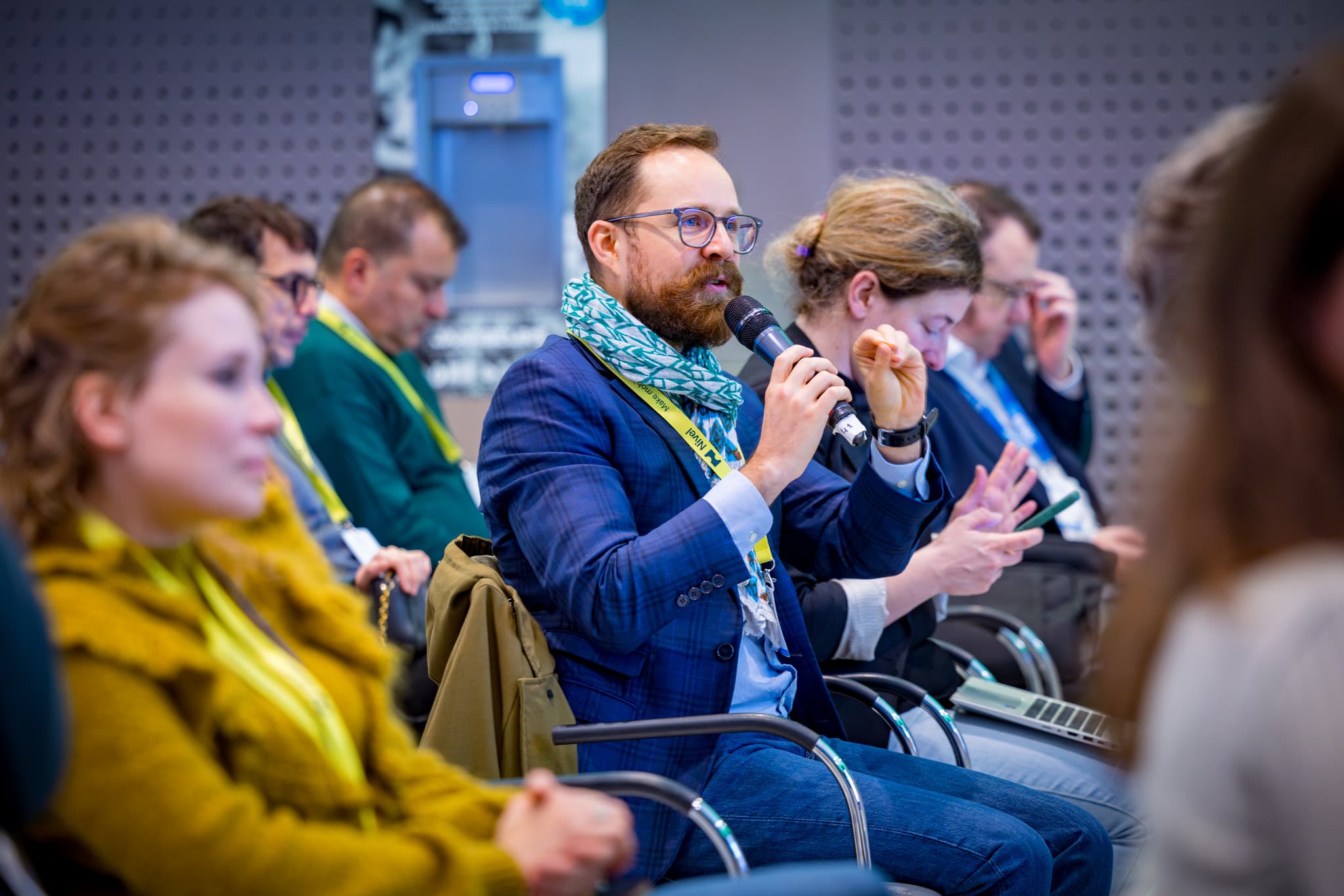 Publiek aan microfoon tijdens congres